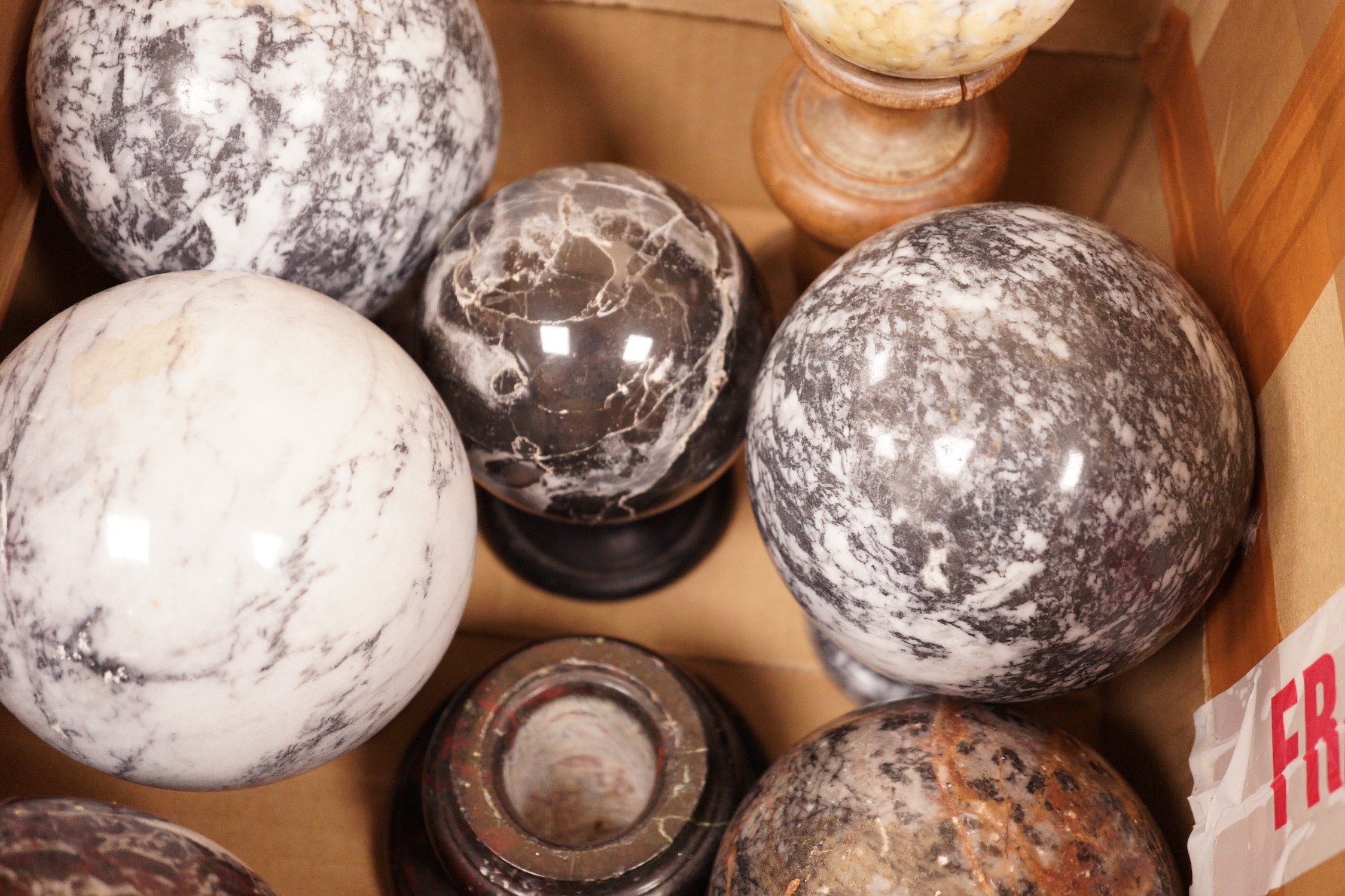 A quantity of carved marble balls on stands